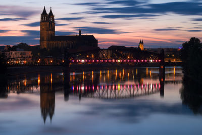 Reflection of buildings in river at sunset