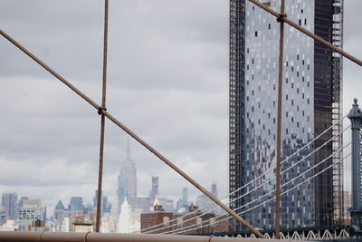 Modern building seen through cables of bridge