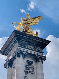 Low angle view of statue against cloudy sky