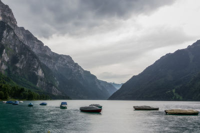View of boats in lake against cloudy sky
