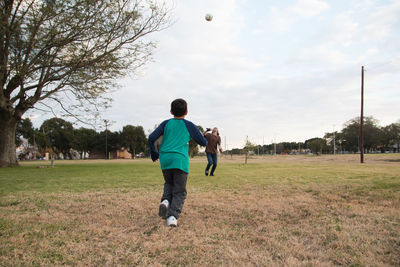 Boy playing soccer with his father outdoors