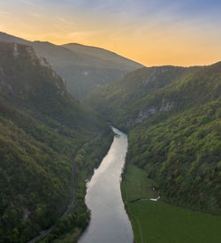 Scenic view of river amidst mountains against sky