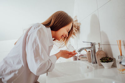 Woman with arms raised in bathroom