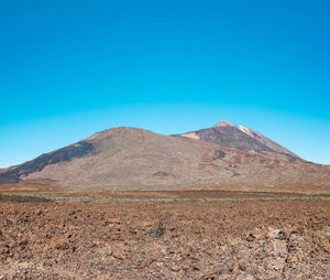 Scenic view of mountains against clear blue sky