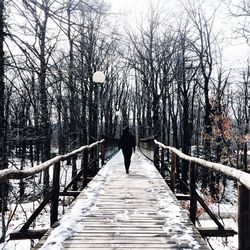 Rear view of man standing on footbridge