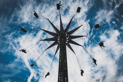 Low angle view of chain swing ride against sky