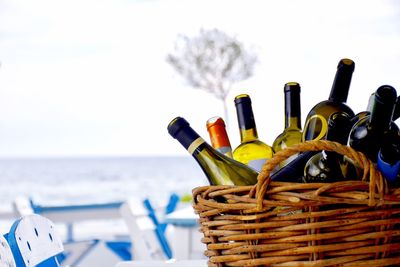 Close-up of multi colored pencils in row at beach against sky