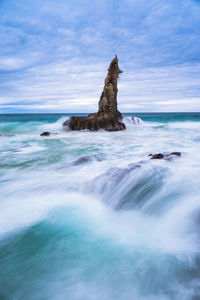 Scenic view of rocks in sea against sky