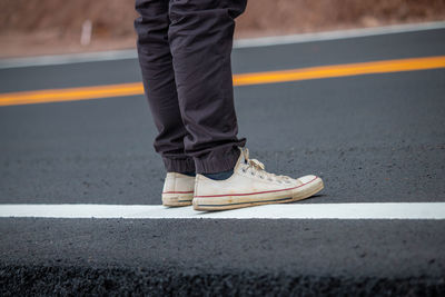 Low section of man standing on roadside