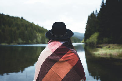 Rear view of woman looking at lake against sky