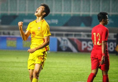 Full length of boys playing soccer on field