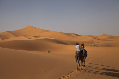 Person riding horse in desert