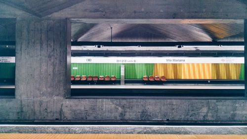 Chairs at railroad station platform seen through window