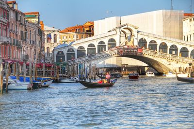 Rialto bridge over grand canal against blue sky