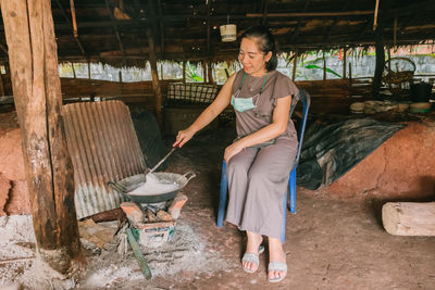 Full length of young woman standing by logs