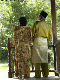 Rear view of couple standing in gazebo at yard