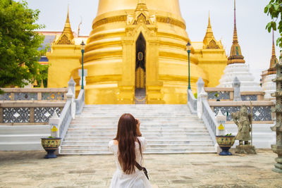 Rear view of woman standing against temple