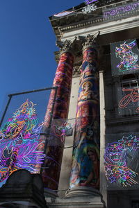 Low angle view of graffiti on building against sky