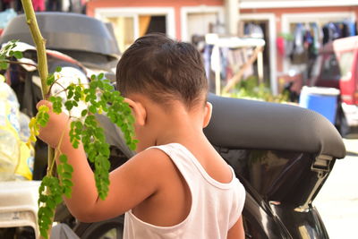 Rear view of boy sitting outdoors