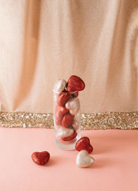 Red and gold glitter hearts in glass with copy space. valentine's day celebration concept.