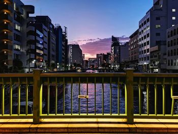 Modern buildings against sky at sunset