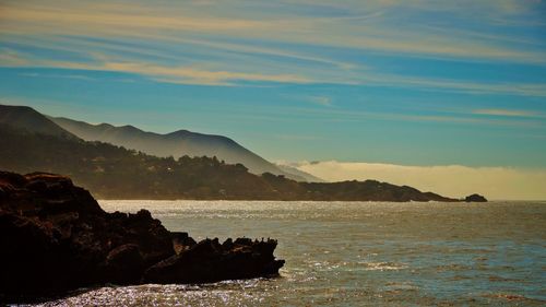 Scenic view of river by rock formations against sky