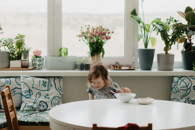 A little girl is sitting at the kitchen table eating soup. high quality photo