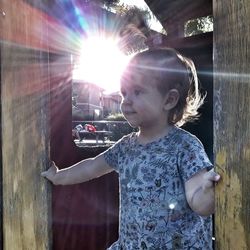 Cute girl looking away while standing at doorway