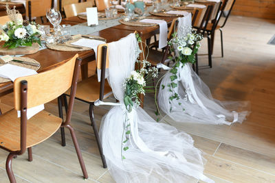 Wedding chairs decorated with white tulle and flowers