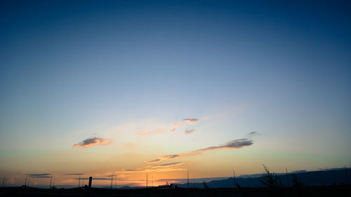 Low angle view of silhouette building against blue sky