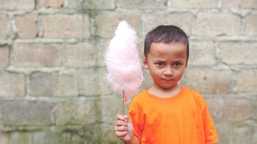 Portrait of boy standing against wall