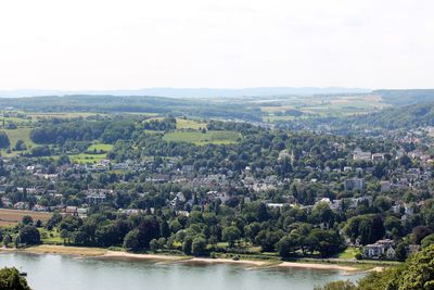 Scenic view of river by cityscape against sky