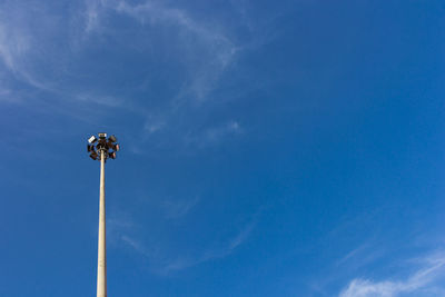 Low angle view of floodlight against blue sky