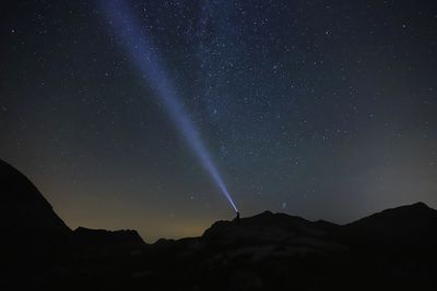 Low angle view of silhouette mountain against sky at night