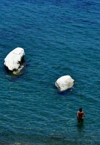 High angle view of people on rock in sea