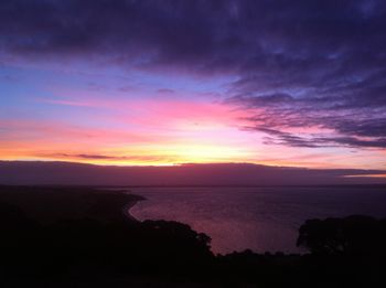 Scenic view of sea against dramatic sky during sunset