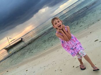 Portrait of girl walking on sand at beach