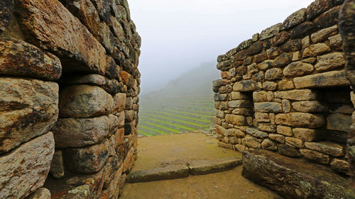 Stack of stone wall against sky