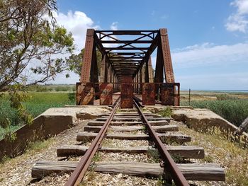 Railroad tracks on field against sky