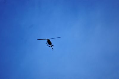 Low angle view of airplane against clear blue sky