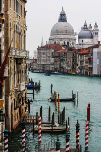 Boats in canal by buildings in city