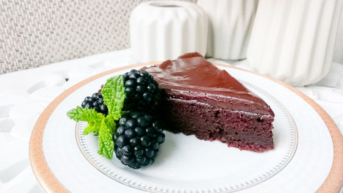 Close-up of brownie with blackberries served on table