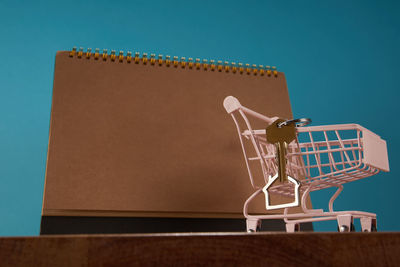 Close-up of shopping cart against blue background