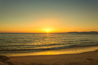 Scenic view of sea against clear sky during sunset