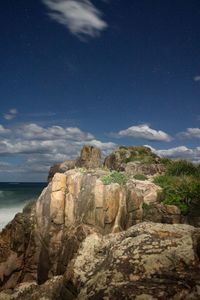 Scenic view of cliff by sea against sky