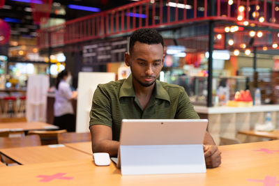 Young man using laptop at table