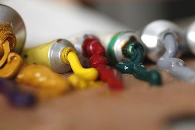 Close-up of colorful paints spilled from tubes on wooden table