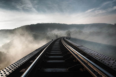 Railroad tracks in foggy weather against sky