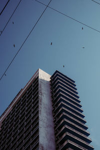 Low angle view of modern building against blue sky