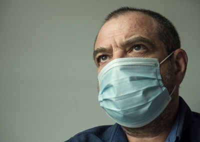 Portrait of man wearing hat against gray background
